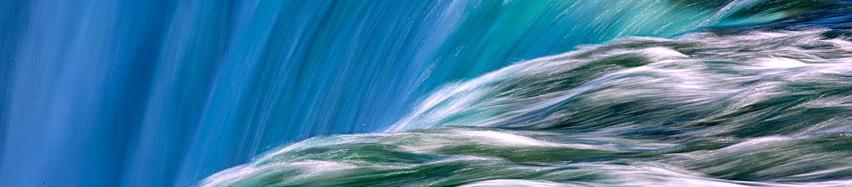 Fast-moving water cascading over a ledge into a waterfall.